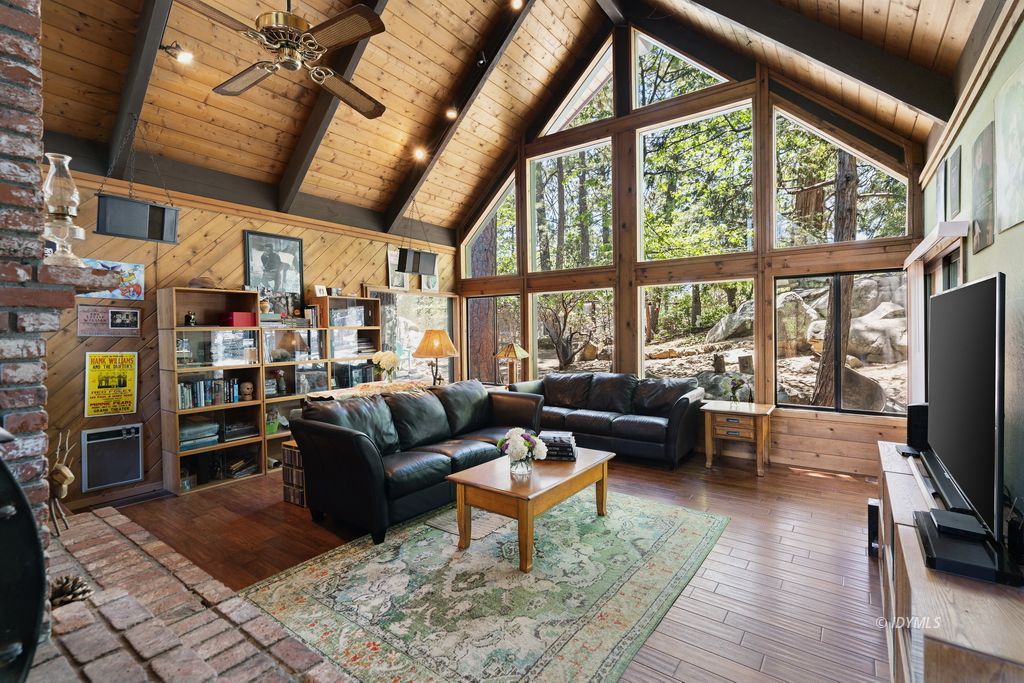 25575 Sunrise Drive Idyllwild, CA 92549 - Photo 1 of 35 a living room with furniture a flat screen tv and a fireplace