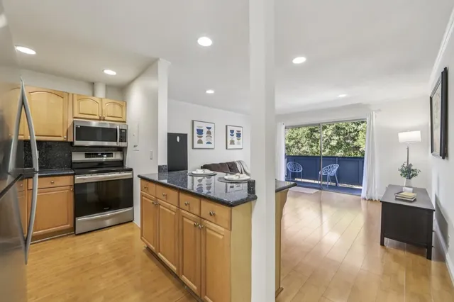 a kitchen with stainless steel appliances granite countertop a refrigerator a stove and a sink