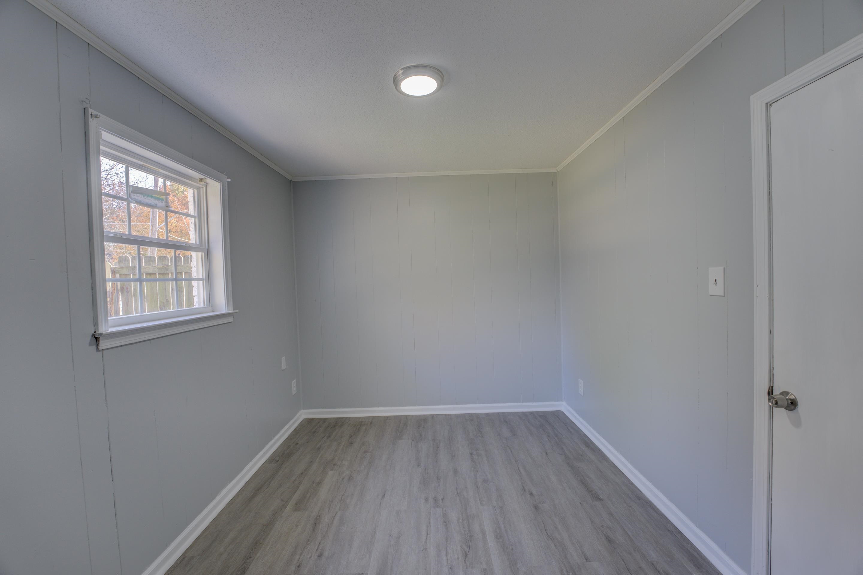 3482 Clarke Road Memphis, TN 38115 - Photo 22 of 29 an empty room with wooden floor and windows