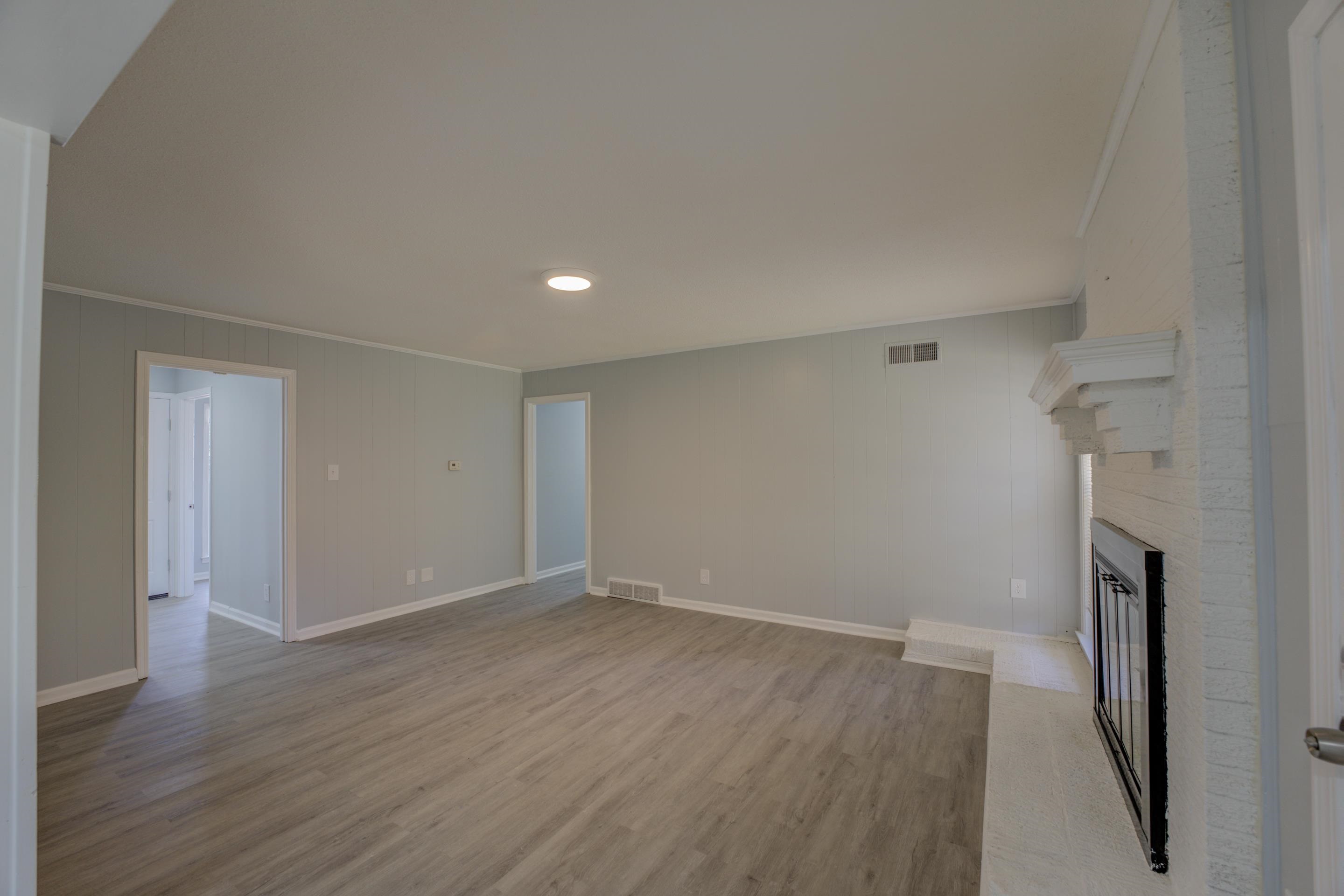 3482 Clarke Road Memphis, TN 38115 - Photo 7 of 29 a view of an empty room with wooden floor and a hallway
