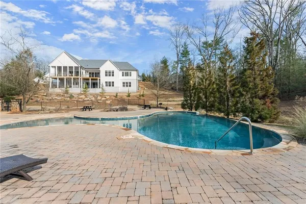 a view of a swimming pool with a yard and trees