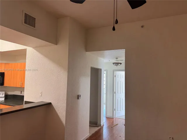 a view of a hallway with wooden floor