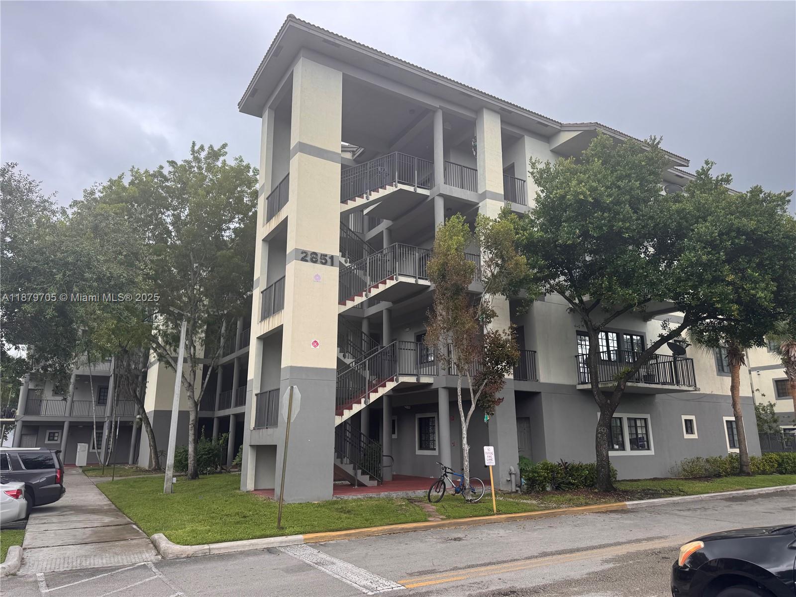 2851 Riverside Drive, Unit 203N Coral Springs, FL 33065 - Photo 5 of 5 a front view of a building with a garden and plants