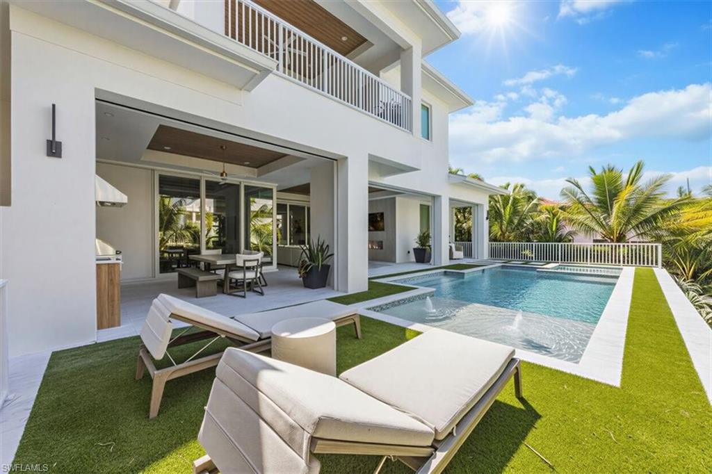 493 8th Avenue South Naples, FL 34102 - Photo 2 of 40 a view of a house with swimming pool and sitting area