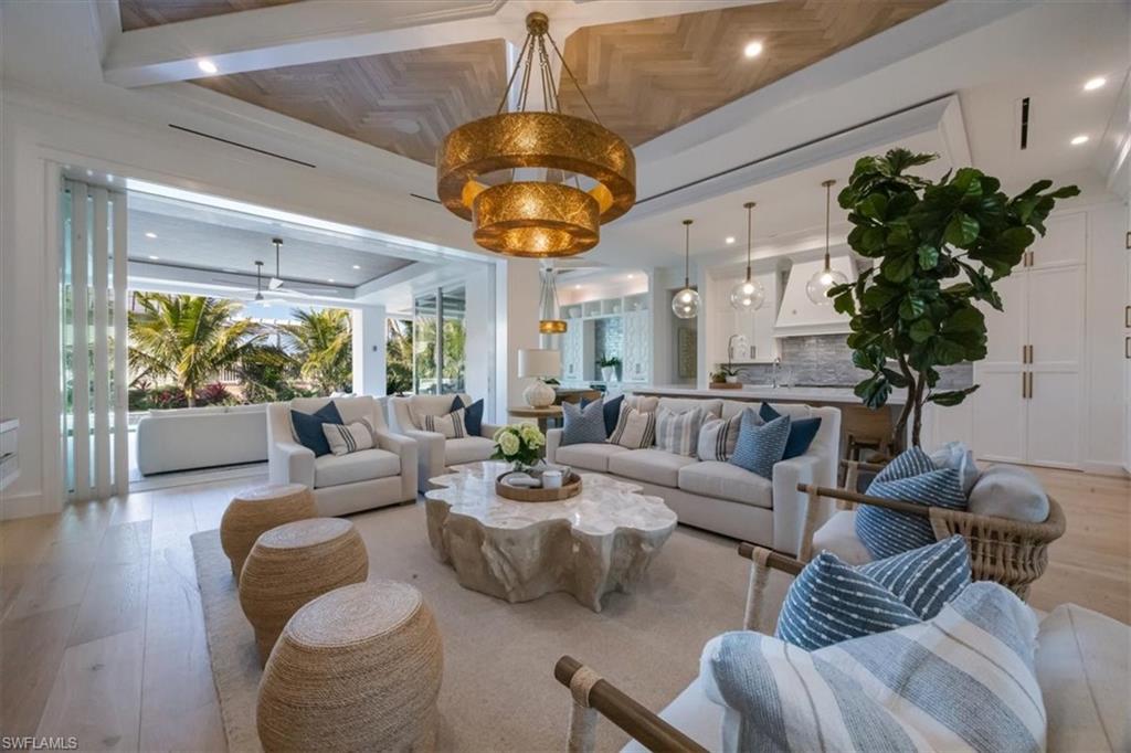 493 8th Avenue South Naples, FL 34102 - Photo 10 of 40 a living room with furniture potted plant and a chandelier