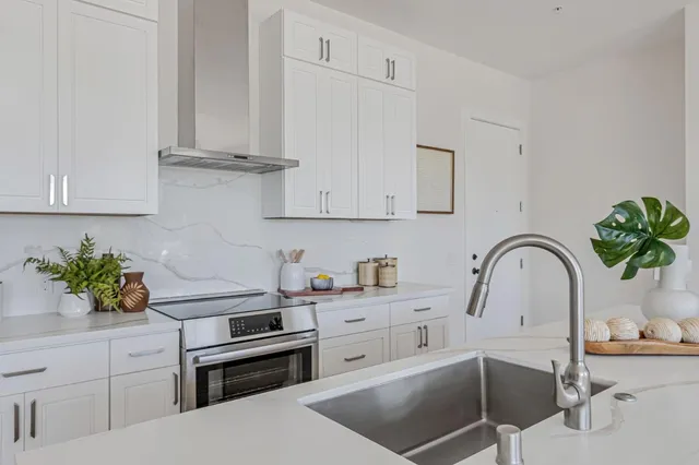 a kitchen with stainless steel appliances a sink a stove and cabinets