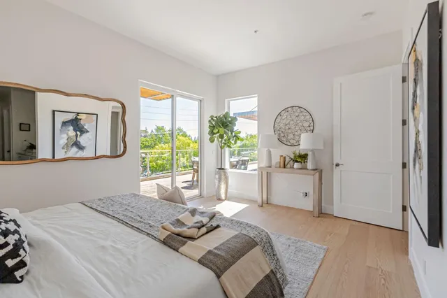 a bed room with a bed a mirror and a large window