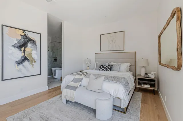 a bedroom with a bed and a painting on the wall