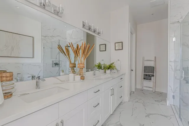 a bathroom with a double vanity sink mirror and next to a window