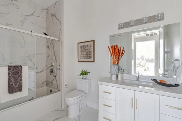 a bathroom with a double vanity sink toilet and shower