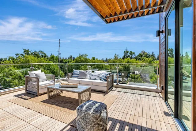 a view of a balcony with wooden floor and outdoor seating