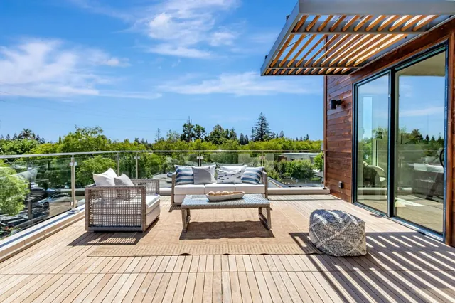 a view of a roof deck with couches and wooden floor