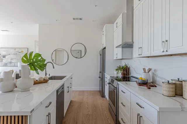 a kitchen with a sink cabinets and wooden floor
