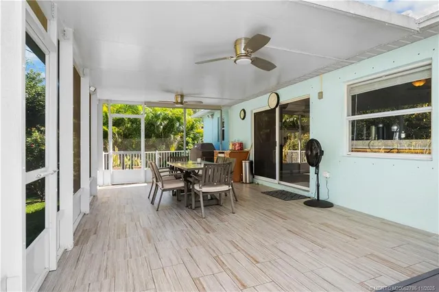 a dining room with wooden floor and chandelier