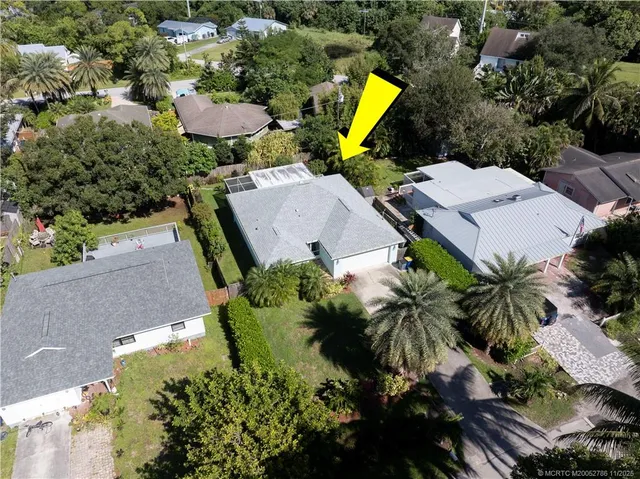 an aerial view of a house with swimming pool and garden space