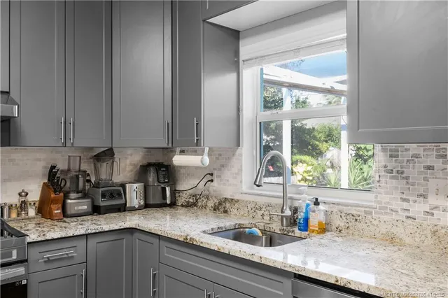 a kitchen with stainless steel appliances granite countertop a sink a counter space and cabinets
