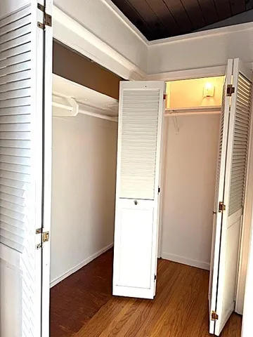 a view of walk in closet with wooden floor