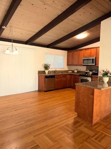a kitchen with stainless steel appliances granite countertop a stove a sink and a microwave
