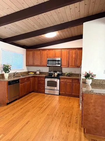a kitchen with stainless steel appliances granite countertop a stove a sink and a microwave