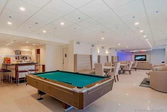 a room with pool table and a couch
