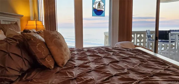 a bedroom with a bed and large windows