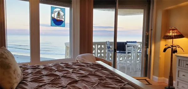 a bedroom with a bed and large windows