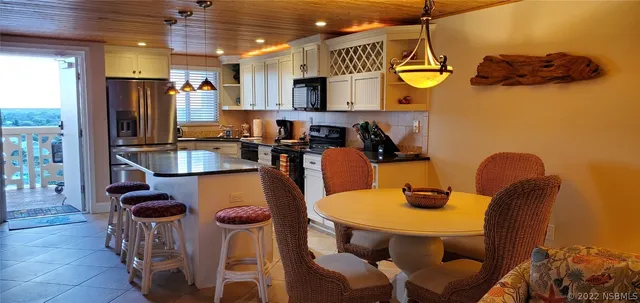a view of a dining room with furniture and a chandelier