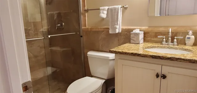 a view of a balcony with two chairs and a potted plant