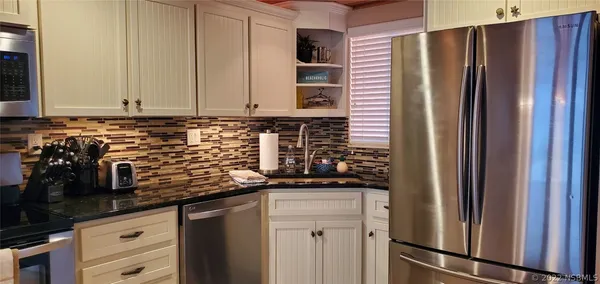 a kitchen with stainless steel appliances granite countertop a refrigerator and a sink