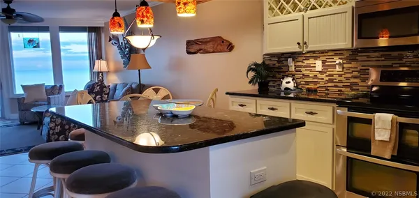 a kitchen with stainless steel appliances granite countertop a sink a stove and cabinets