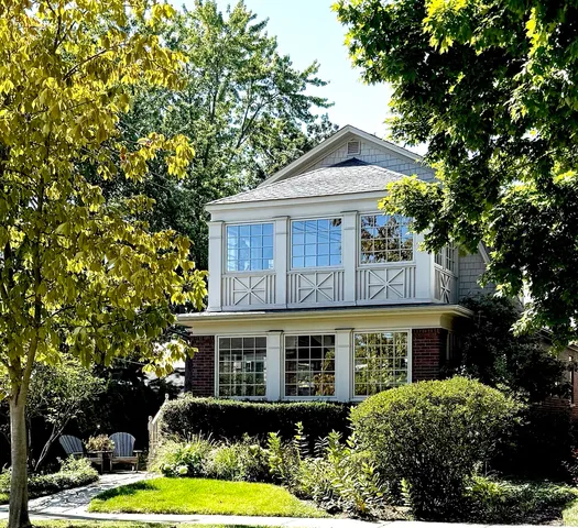 a front view of a house with a yard and potted plants