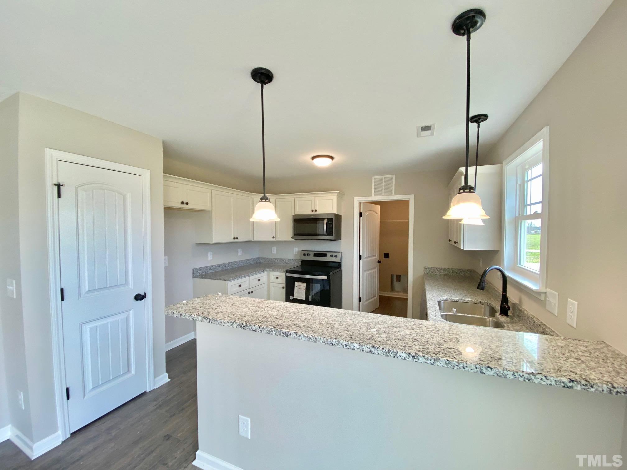120 Mamie Road Benson, NC 27504 - Photo 14 of 35 a view of a kitchen with kitchen island a sink stainless steel appliances and cabinets
