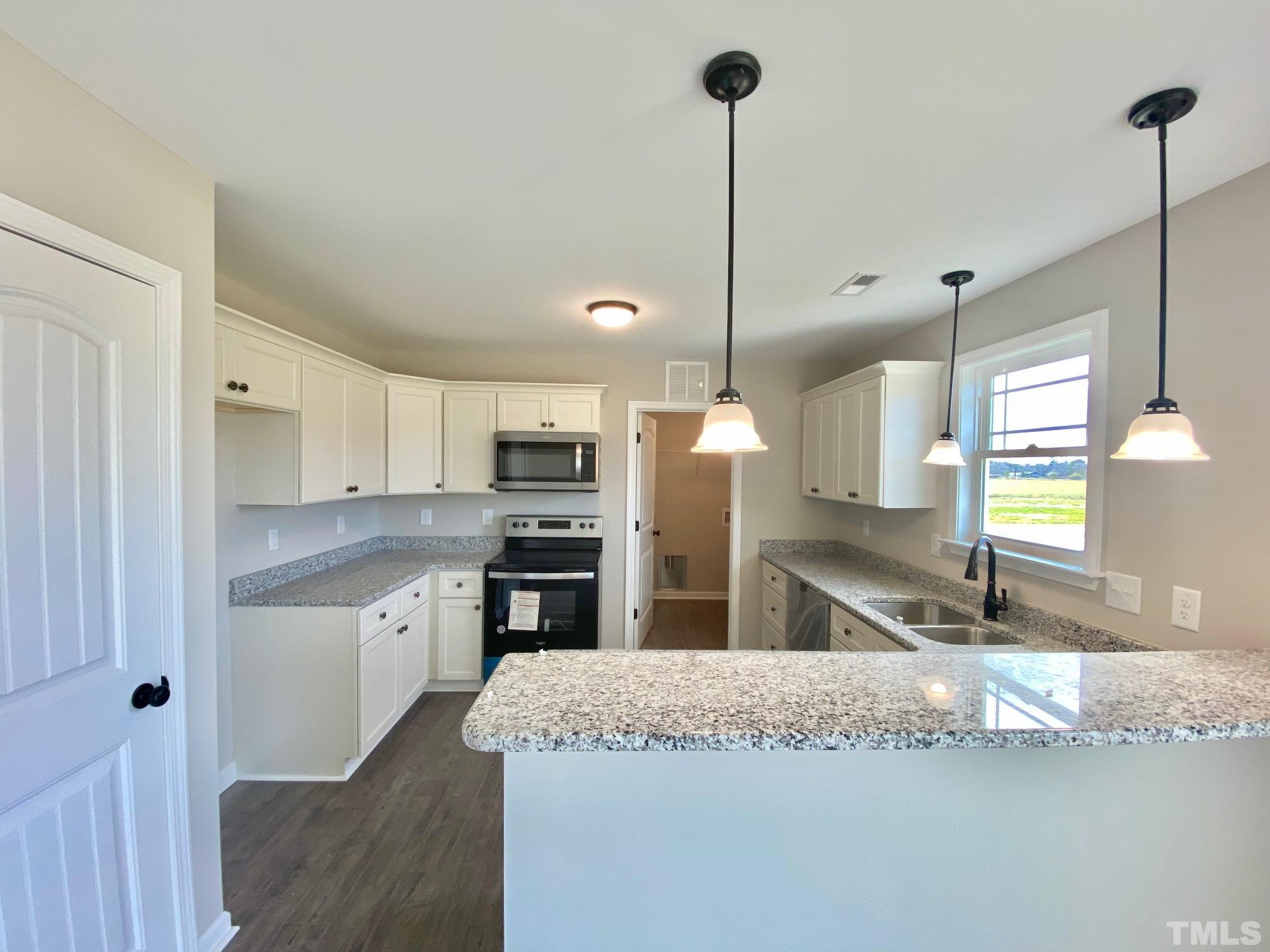120 Mamie Road Benson, NC 27504 - Photo 15 of 35 a kitchen with stainless steel appliances granite countertop a sink a stove and a wooden floors