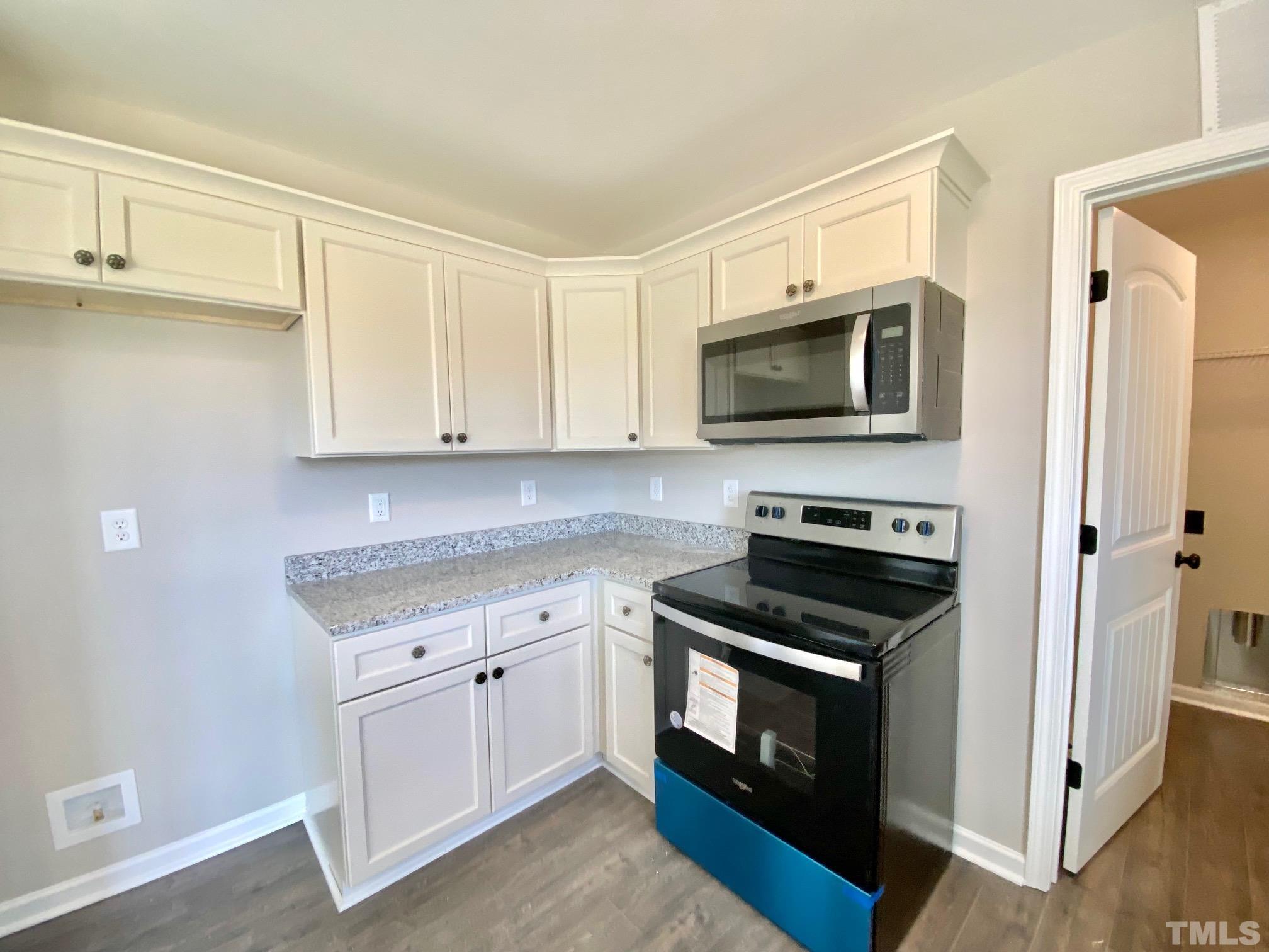 120 Mamie Road Benson, NC 27504 - Photo 18 of 35 a kitchen with white cabinets and black appliances