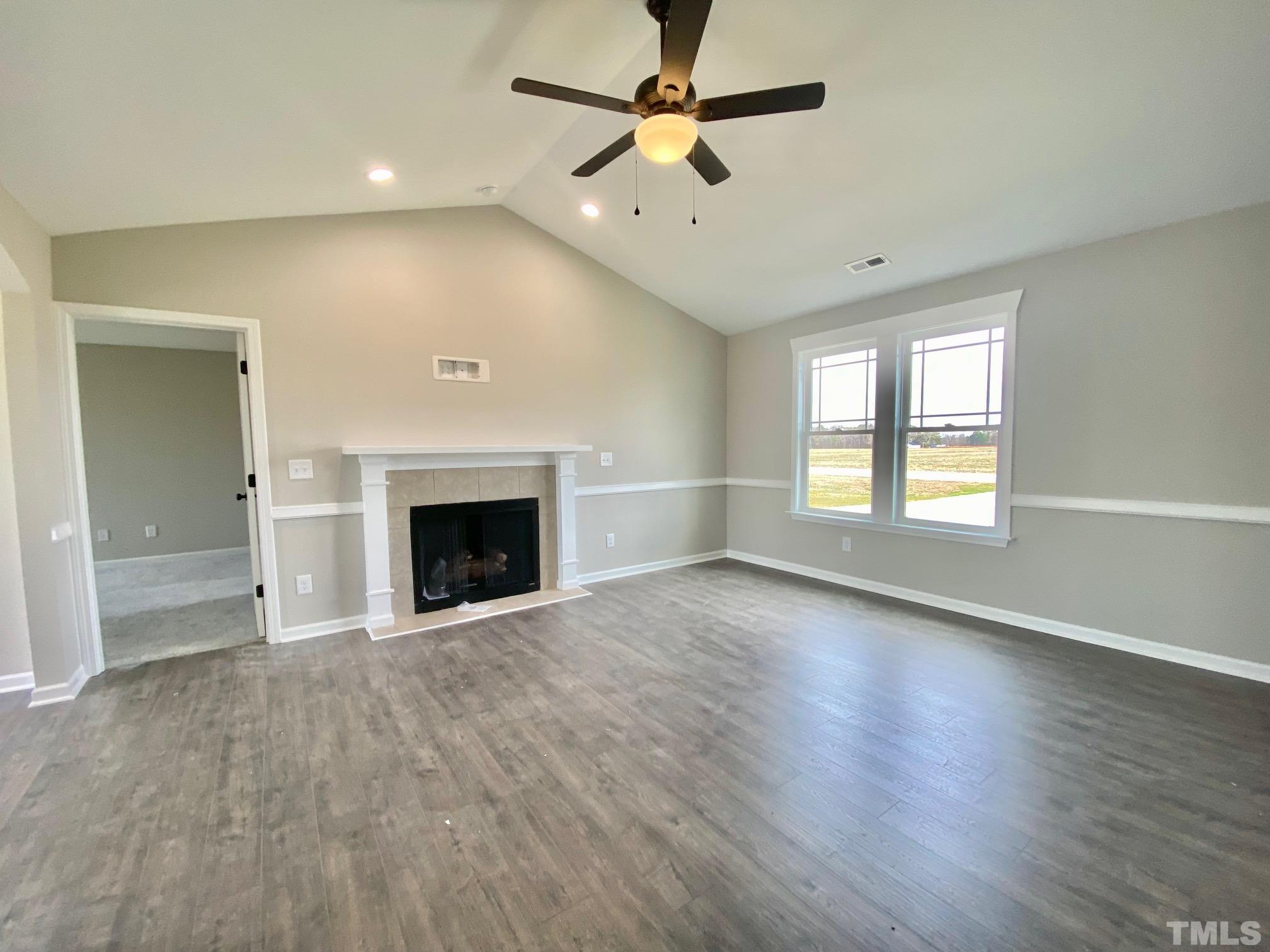 120 Mamie Road Benson, NC 27504 - Photo 8 of 35 an empty room with windows and a fireplace