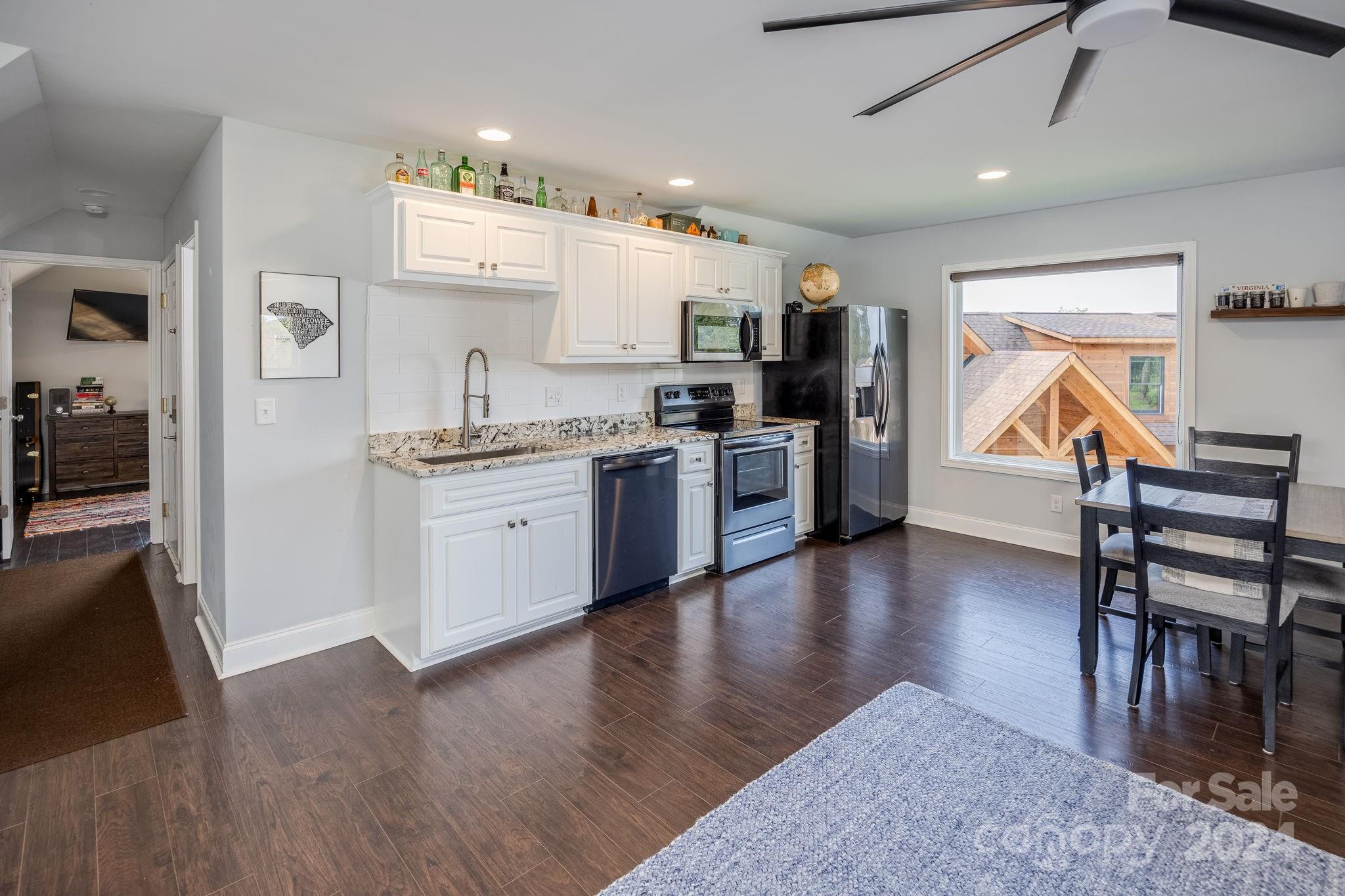 1958 Boxelder Trail Ridgeway, SC 29130 - Photo 40 of 46 a kitchen with stainless steel appliances granite countertop a stove refrigerator dining table and chairs
