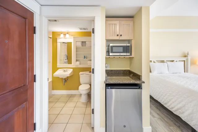 a bathroom with a granite countertop sink and a toilet