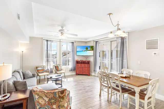 a living room with furniture a chandelier and a dining table
