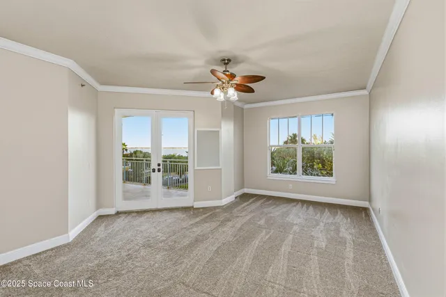 a view of an empty room with a chandelier fan