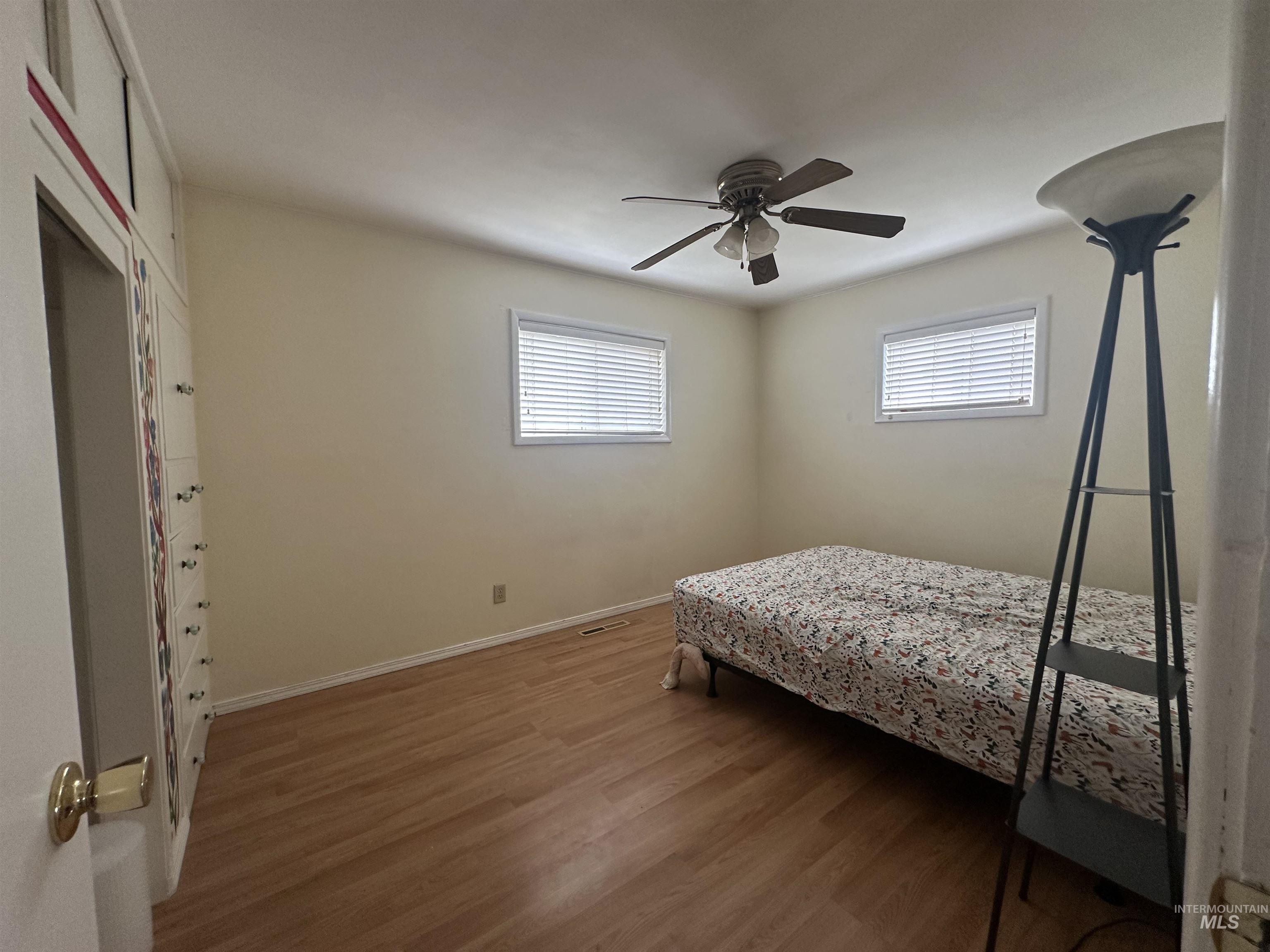630 Preston Avenue, Unit C Lewiston, ID 83501 - Photo 8 of 10 Room featuring wood-finish flooring, two windows with blinds, and a ceiling fan with integrated lighting