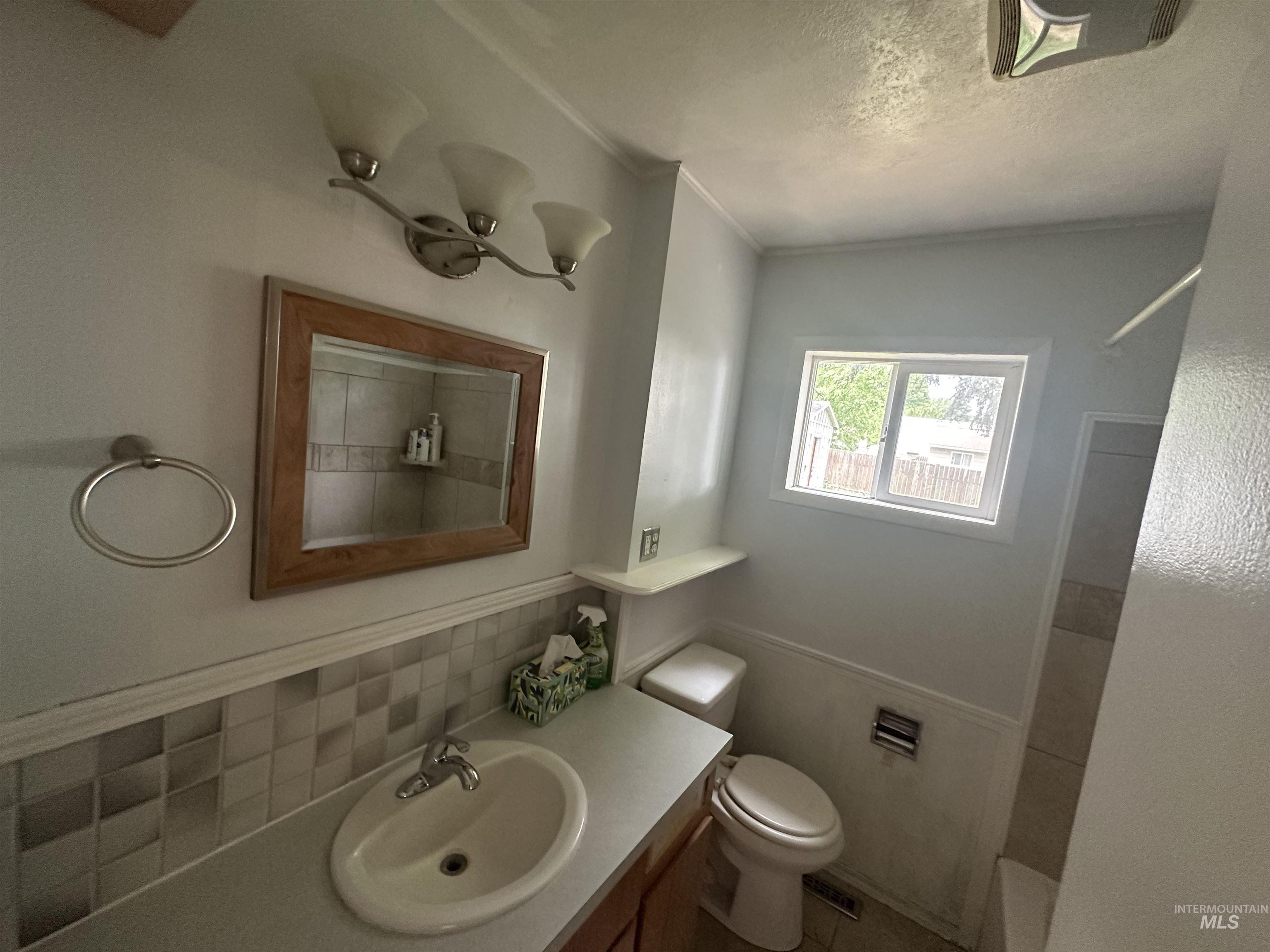 630 Preston Avenue, Unit C Lewiston, ID 83501 - Photo 10 of 10 Bathroom featuring a single vanity, wood-framed mirror, and a window for natural light