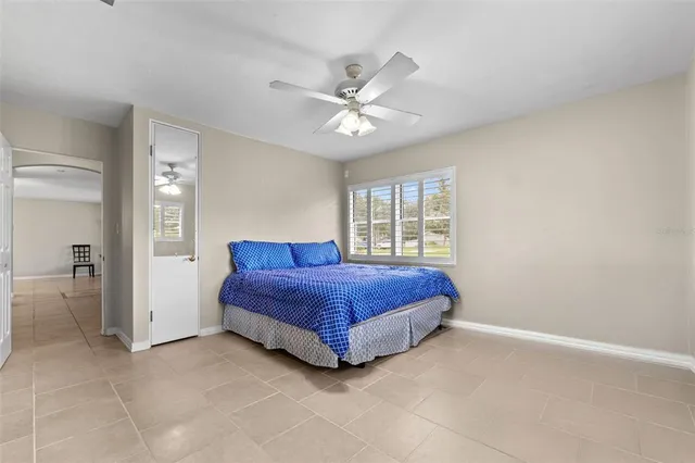a spacious bedroom with a bed and a chandelier
