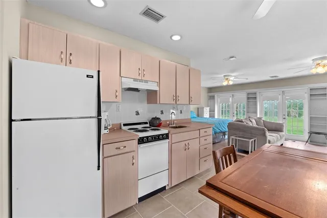 a kitchen with stainless steel appliances a refrigerator sink stove and white cabinets
