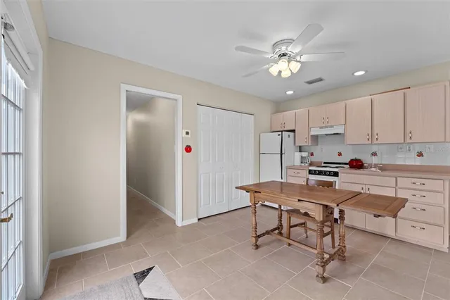 a room with stainless steel appliances kitchen island granite countertop furniture and a refrigerator