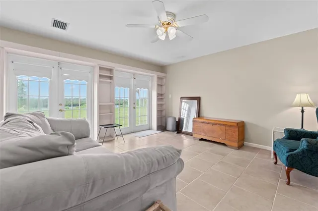 a spacious bedroom with a bed a chandelier and a couch
