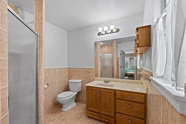 a bathroom with a granite countertop toilet a sink and a mirror