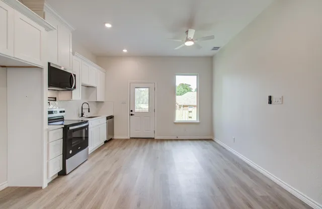 a kitchen with appliances a sink and cabinets