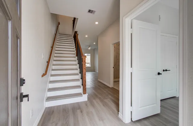 a view of a hallway with wooden floor and entryway