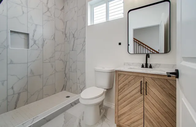 a kitchen with granite countertop a sink cabinets and stainless steel appliances