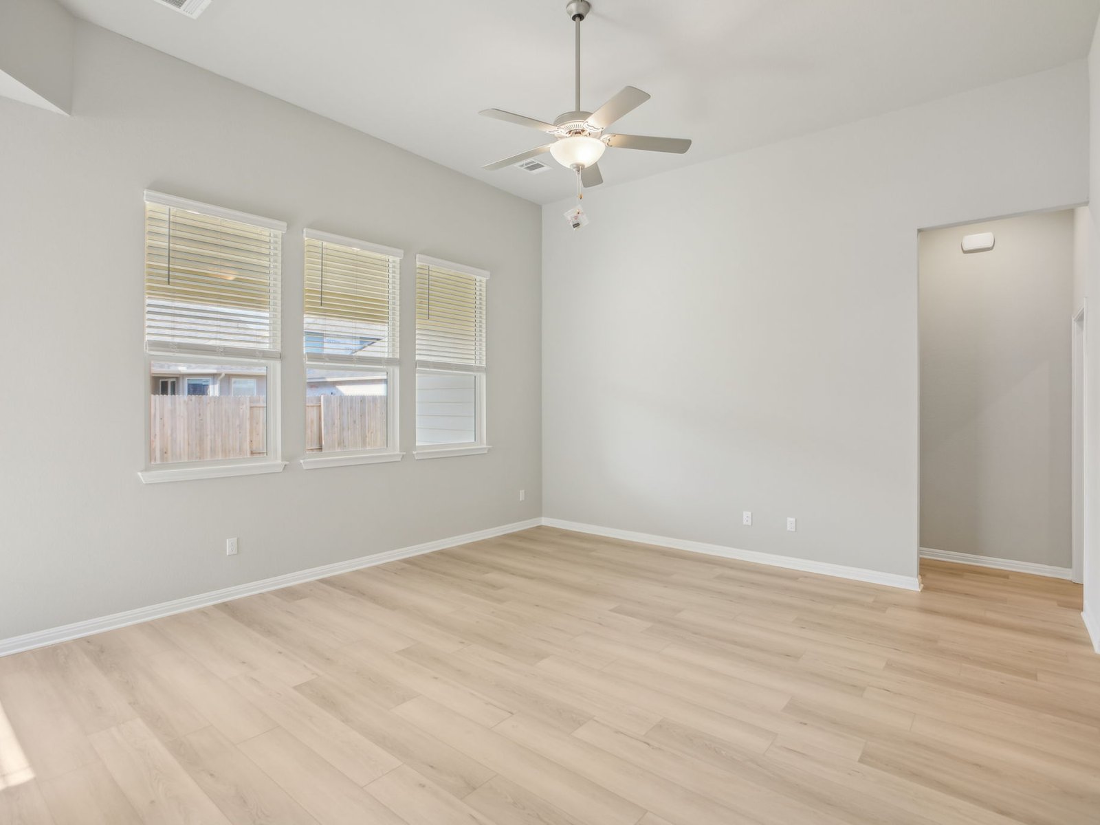 129 Pendleton Drive Kyle, TX 78640 - Photo 3 of 11 a view of an empty room with wooden floor and a window